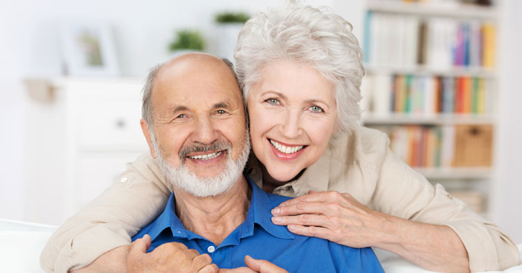 Stock image of an elderly couple smiling after Peri-Implantitis treatment.