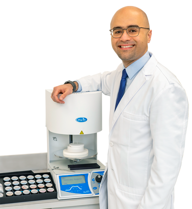 Dr. Al Sakka standing next to high-tech dental equipment.