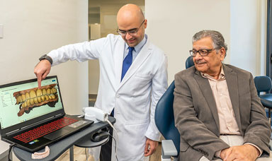 Dr. Al Sakka showing a patient digitized scans of their teeth during a consultation.