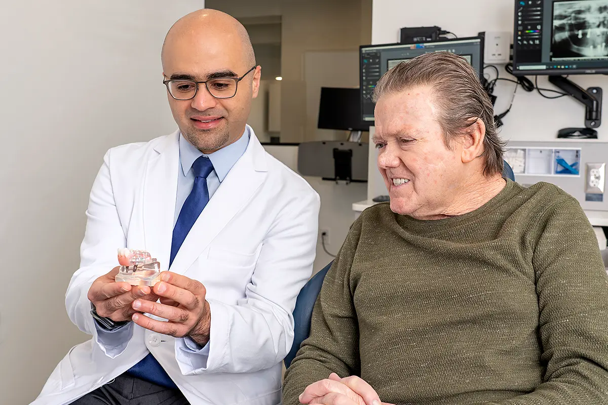 Dr. Koticha and Dr. Al Sakka showing a patient Dental Implant planning software during a consultation.