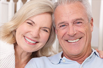 Stock image of an elderly couple smiling after Full-Mouth Rehabilitation.